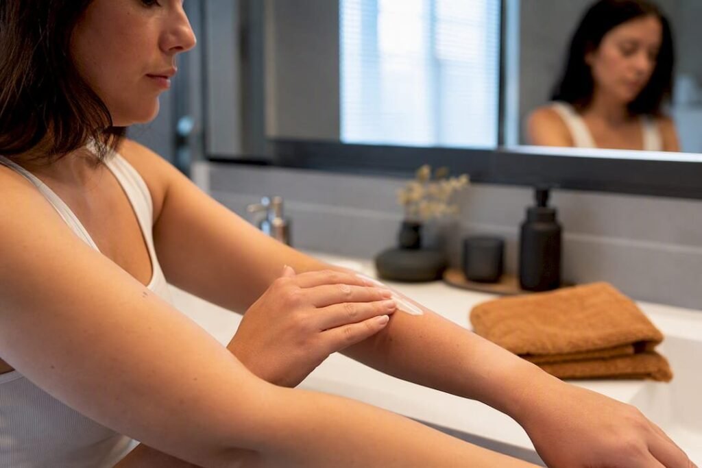 Application d'une crème apaisante sur une jambe après une séance d'épilation laser